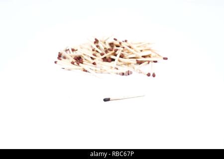 Many match sticks and one burnt matchstick. Isolated on the white background. Stock Photo