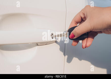 Closeup hand woman holding key opening car door. Stock Photo