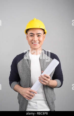 Handsome civil engineer working with documents on gray background Stock Photo