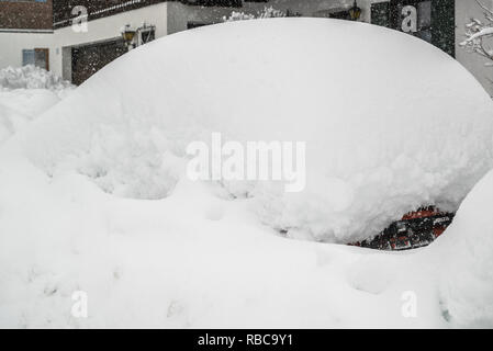 Snow on cars after snowfall. Winter urban scene. Car is complete covered. Chaos and catastophe alert in bavaria germany Stock Photo