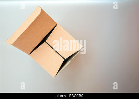 Half closed, half opened big square cardboard craft gift box on the silver gray metal background Stock Photo