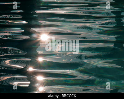 closeup of the sun reflected on the water of a pool Stock Photo