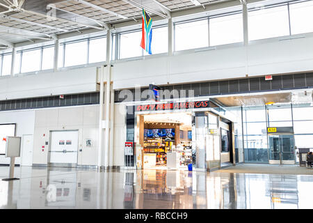 Dulles, USA - June 13, 2018: Duty free Americas shop, store with people, passengers walking with luggage, baggage, bags at Dulles International Airpor Stock Photo