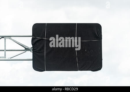 Miami, USA Road street highway black construction cover on sign in Florida tied with string isolated against cloudy white sky Stock Photo