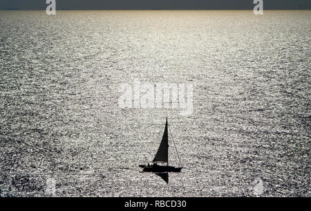 Small sailing boat on shining sea. Stock Photo