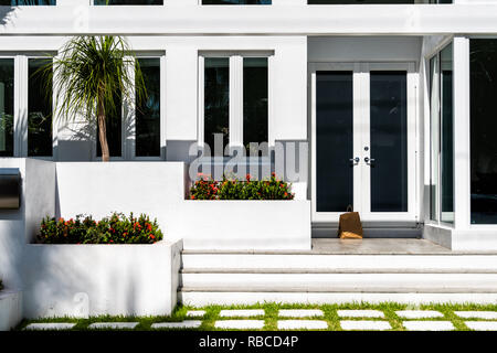 https://l450v.alamy.com/450v/rbcd4p/luxury-modern-entrance-architecture-of-house-in-florida-city-on-sunny-day-property-real-estate-with-garden-landscaping-decoration-dark-glass-windows-rbcd4p.jpg