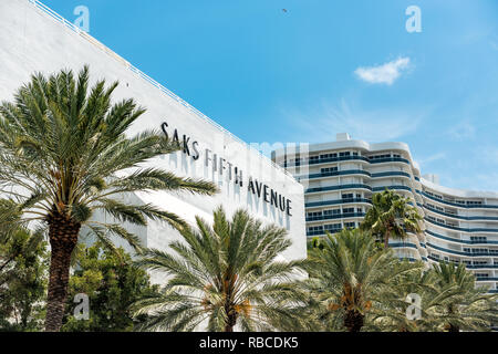 Bal Harbour, USA - May 8, 2018: Bay Harbor in Miami Florida with green palm trees on exterior of condo apartment building by mall for Saks Fifth Avenu Stock Photo