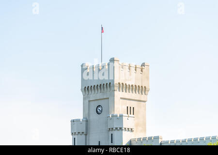 Charleston, USA - May 12, 2018: Citadel Military College of South Carolina closeup exterior of clock tower building and American flag isolated against Stock Photo
