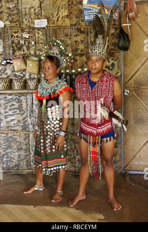 Iban woman and man in traditional tribal dress, Mengkak Longhouse, Batang Ai, Sarawak (Borneo), Malaysia Stock Photo