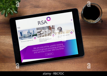 The website of RSA (Royal & Sun Alliance) is seen on an iPad tablet, resting on a wooden (Editorial use only). Stock Photo