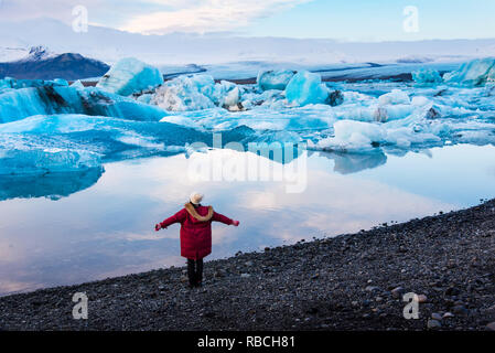 Woman at Jokulsarlon Glacier Lagoon in Iceland at sunset Stock Photo