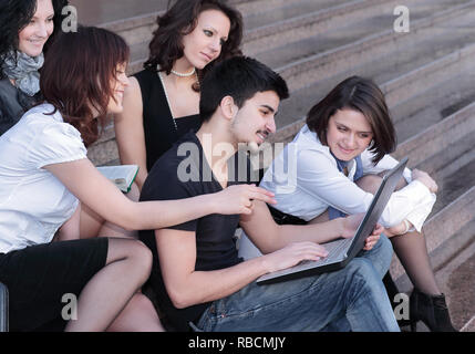 group of students communicating via the Internet using laptop Stock Photo