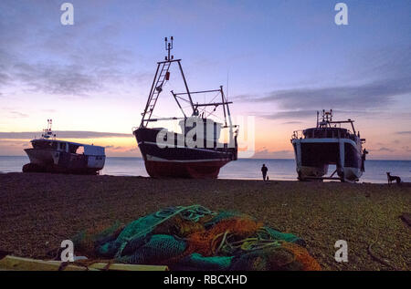 Hastings, East Sussex, UK. 9th Jan 2019. Cold start to the day for dog walkers at dawn on the Stade Fishermen's Beach. Hastings has the largest beach launched fishing fleets in Europe. Stock Photo