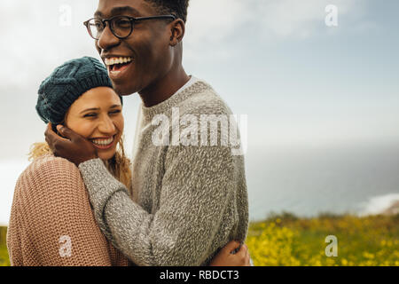Loving interracial couple spending time together outdoors. Young man with her beautiful girlfriend. Stock Photo