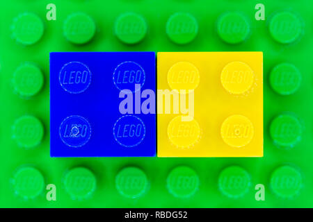 Blue and yellow 2x2 Lego bricks on a green Lego base Stock Photo