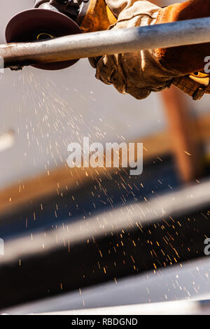 Welder At Shipyard Using Rotary Grinder On Metal Pipe Stock Photo