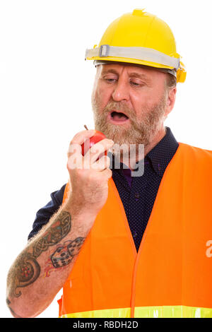 Mature bearded man construction worker eating apple Stock Photo