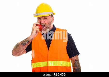 Mature bearded man construction worker eating apple Stock Photo