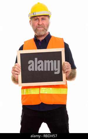 Mature bearded man construction worker holding empty blackboard Stock Photo