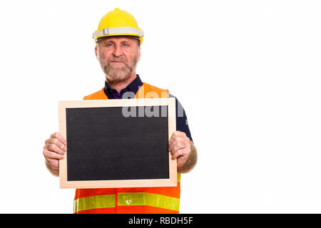 Mature bearded man construction worker holding empty blackboard Stock Photo
