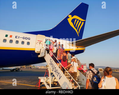 Passengers board on tarmac of Thessaloniki airport. Travelers at apron area of Makedonia airport, boarding from rear entrance of a Ryanair aircraft. Stock Photo