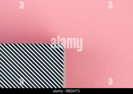 Diagonal black and white stripes on pastel pink background Stock Photo