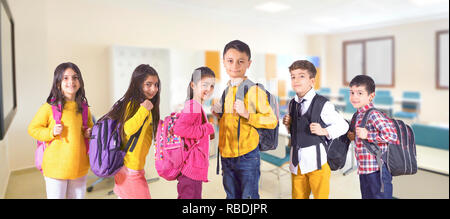 girl and boy students standing together with their backpack Stock Photo