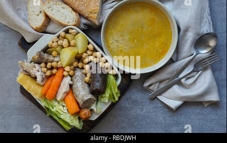 Cocido, traditional chickpea-based stew from Madrid.  on the grey stone background Stock Photo
