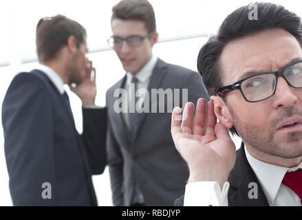 close up.businessman eavesdropping on conversation between colleagues Stock Photo