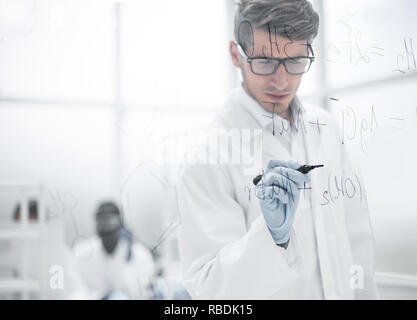 scientist making notes on the glass Board at the time of the experiment Stock Photo
