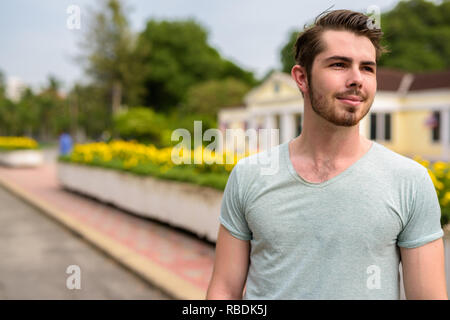 Portrait of young handsome man relaxing at the park Stock Photo