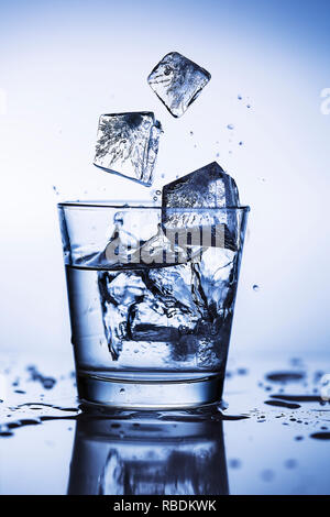 Splash ice cubes in a water glass Stock Photo