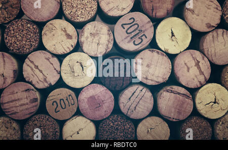 Close up background pattern of many assorted stacked used red wine corks, retro toned Stock Photo
