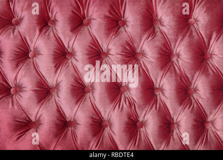 Pastel pink capitone textile background, retro Chesterfield style checkered soft tufted fabric furniture decoration with buttons, close up Stock Photo