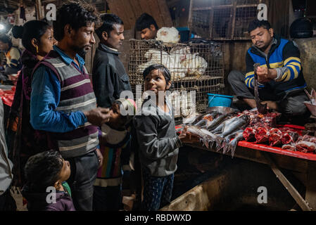 The Fish Stall in JJ Colony, Madanpur Khadar: In the evening the market stall is at its busiest - a young salesperson uses vital skills of negotiation Stock Photo