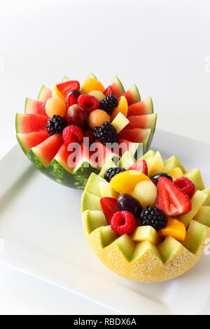 Fancy cut melon and watermelon with assorted fruit inside inicluding strawberries, raspberries, grapes, canteloupe, pineapple, and sliced peaches Stock Photo