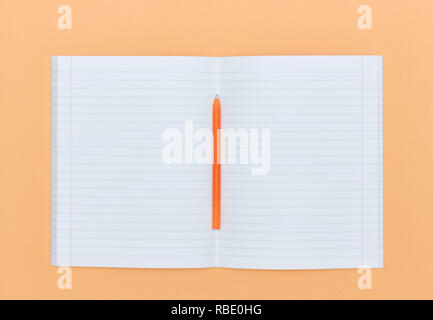 Blank Notepad with pen on orange peach color background. The View From The Top. school subjects and education. white sheet in notebook. Stock Photo