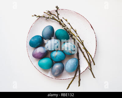Multi-colored Easter eggs, twigs willows and old plate Stock Photo
