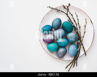 Multi-colored Easter eggs, twigs willows and old plate Stock Photo