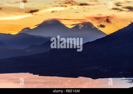 Sunrise over Lake Atitlan & 3 volcanoes. View from Indian Nose, San Juan la Laguna in Guatemalan highlands. Stock Photo