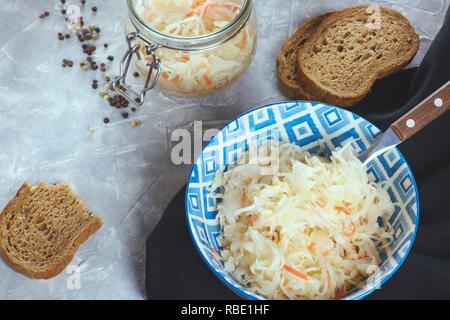 Sauerkraut in a plate on a concrete background. the composition of the feast with sauerkraut. national Russian dish. home preparations for the winter. Stock Photo