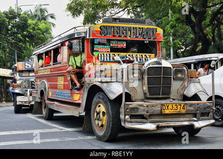 Manila, Philippines-October 24, 2016: Colorist dyipnis-jeepneys are a common means of public transportation all across the country-here stopped at a t Stock Photo