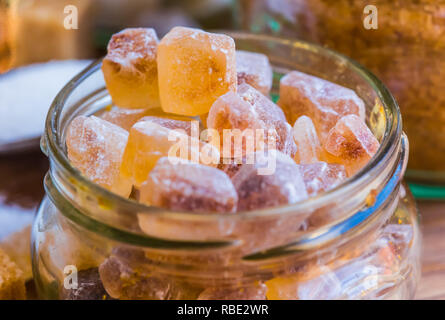 rock candy in glass and different type of sugar blurred in the background Stock Photo