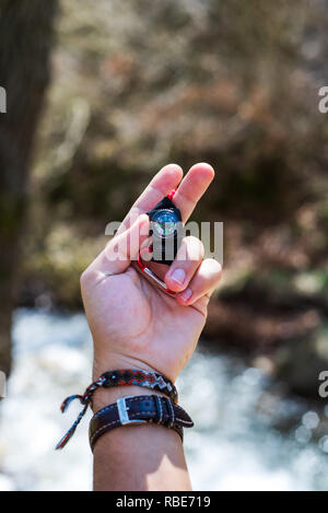 Man holding a small compass close up Stock Photo