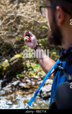 Man holding a small compass close up Stock Photo