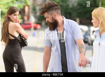 https://l450v.alamy.com/450v/rbe75r/flirting-in-the-street-love-triangle-and-threesome-man-cheating-his-girlfriend-bearded-man-looking-at-other-girl-hipster-choosing-between-two-women-betrayal-and-infidelity-unfaithful-love-rbe75r.jpg