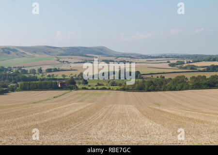 The cut yellow straw of the wheat fields at harvest time looking towards Firle near the South Downs in East Sussex