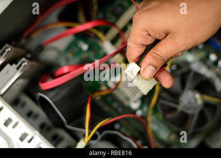 Engineer is repairing electrical wire in a modern electrical equipment in computer. Stock Photo