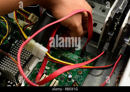 Engineer is repairing electrical wire in a modern electrical equipment in computer. Stock Photo
