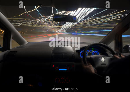 Traffic nighttime trails on motorway with headlights and light trails on Wrotham roundabout Stock Photo